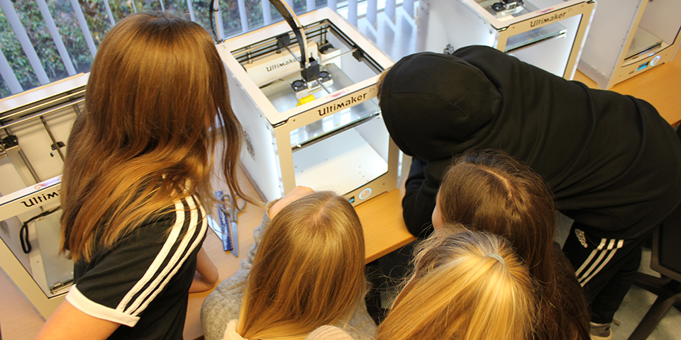 Fem elever kigger på en 3D-printer