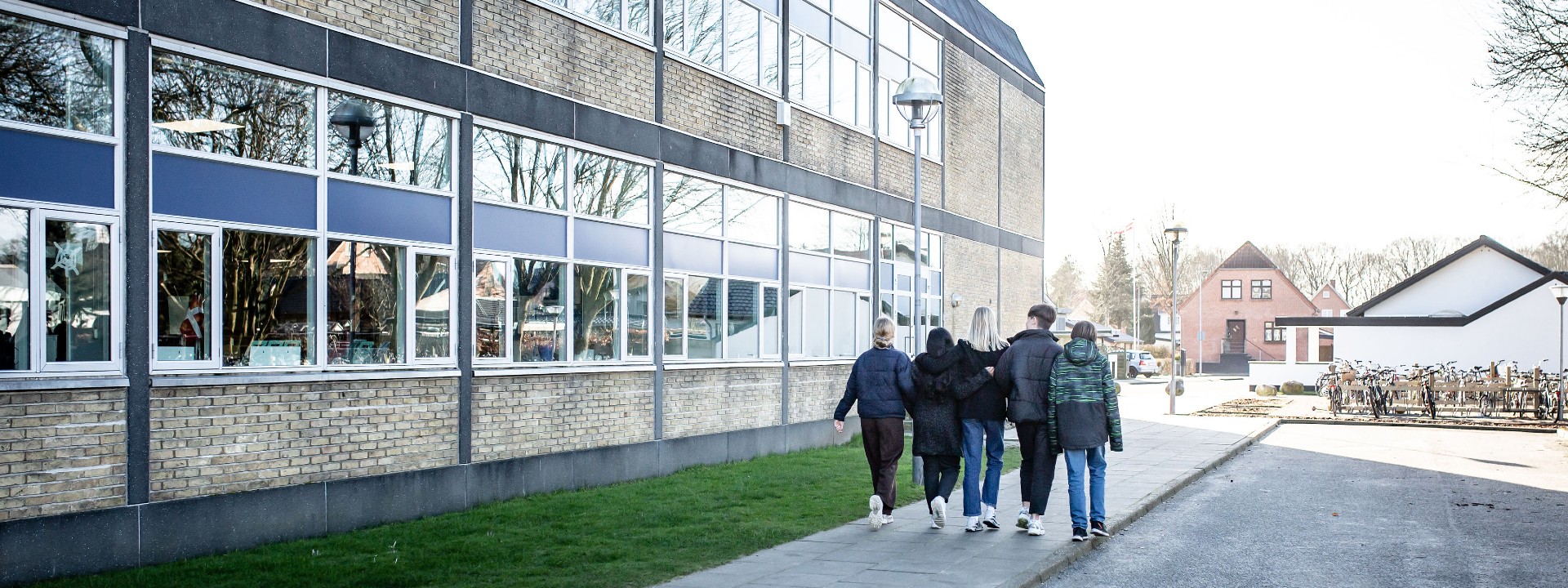 Elever går sammen udenfor en skole