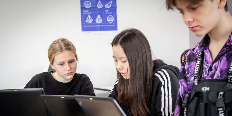 Tre elever arbejder på computer i undervisningen