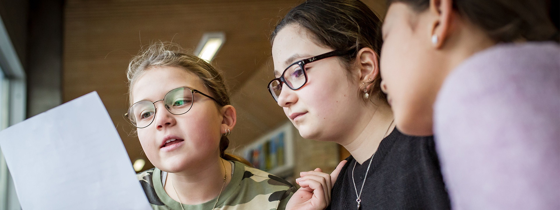 Tre elever kigger på det samme stykke papir