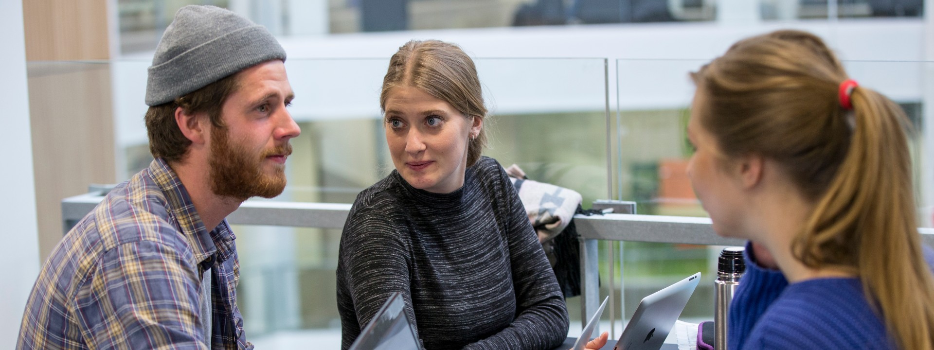 Tre studerende sidder i gruppearbejde