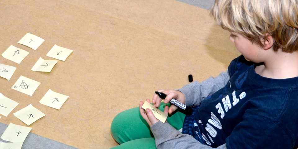 Dreng sidder med tusch og kigger på post-its